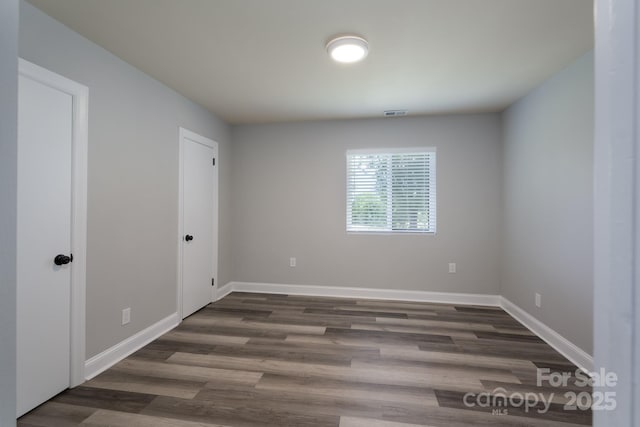 unfurnished room featuring dark wood-type flooring