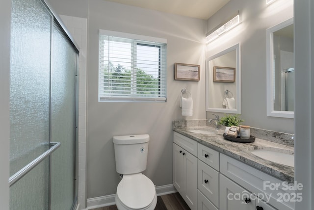 bathroom featuring vanity, an enclosed shower, and toilet