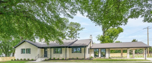 ranch-style home with a carport and a front yard