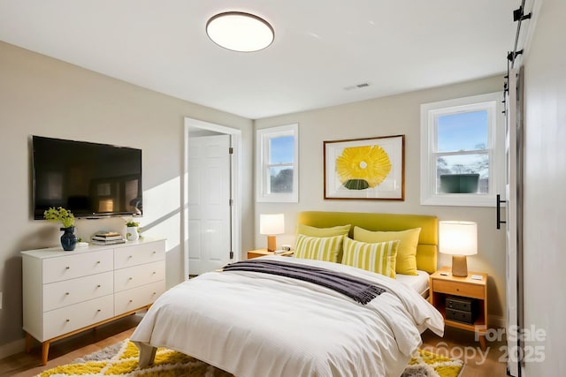 bedroom with dark hardwood / wood-style flooring and multiple windows