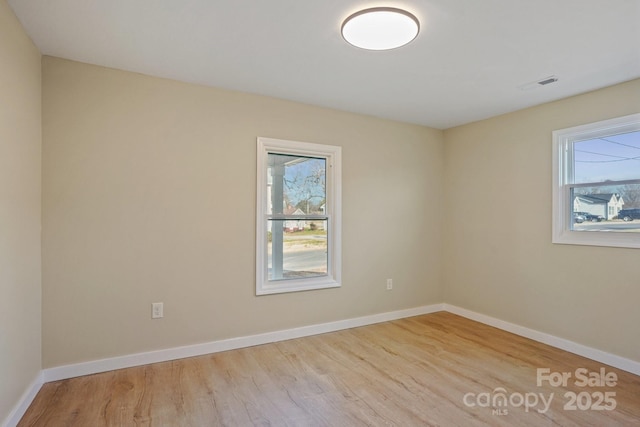 unfurnished room featuring a wealth of natural light and light hardwood / wood-style flooring