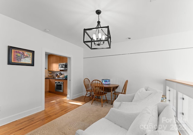 dining room featuring light wood-type flooring and a notable chandelier