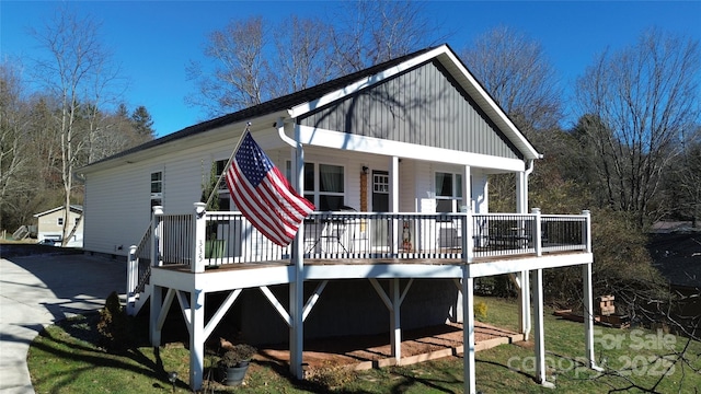 back of property with covered porch and a deck