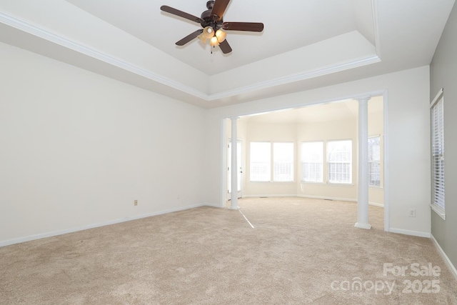 spare room featuring a tray ceiling, ceiling fan, and light colored carpet