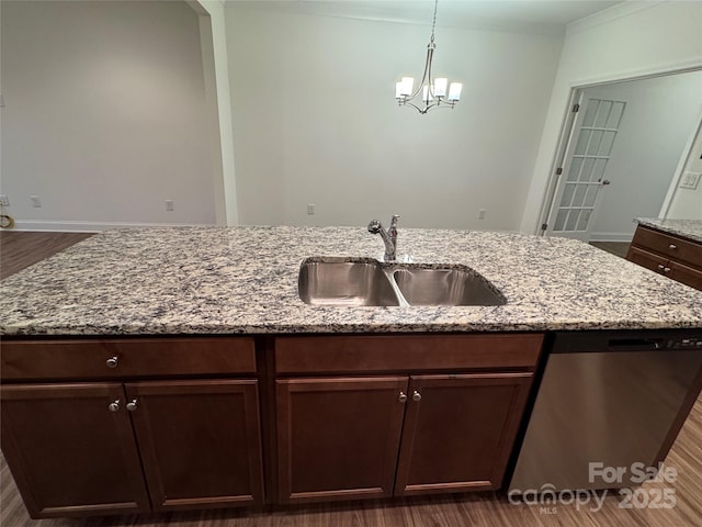 kitchen featuring sink, hanging light fixtures, stainless steel dishwasher, light stone countertops, and an inviting chandelier