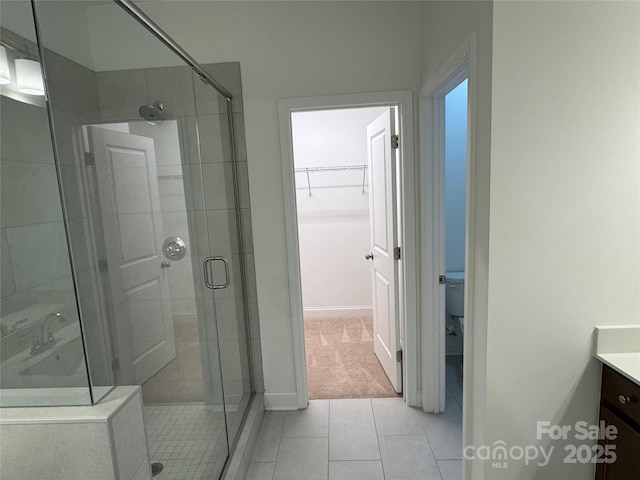 bathroom featuring vanity, toilet, an enclosed shower, and tile patterned flooring