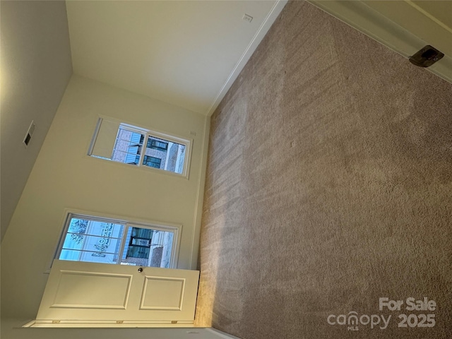 unfurnished living room with a towering ceiling and plenty of natural light