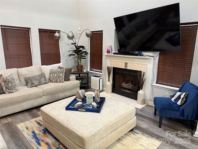 living room featuring a tile fireplace and wood finished floors