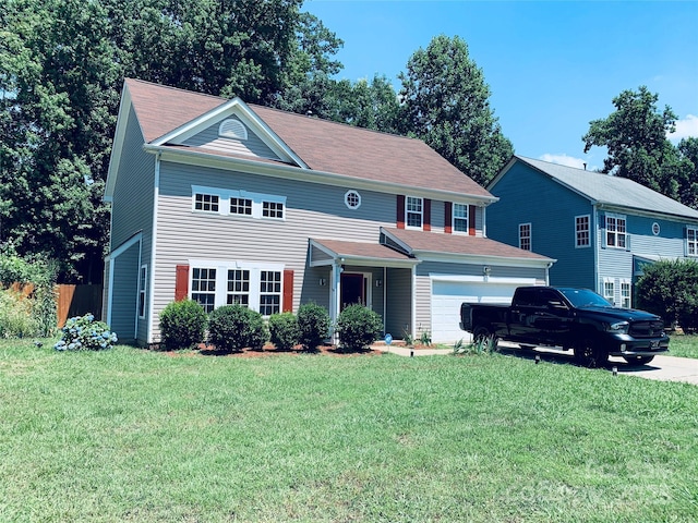 view of front of home featuring driveway, an attached garage, and a front lawn