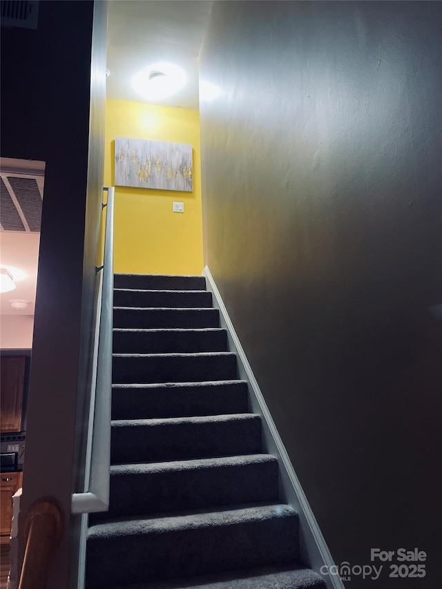 staircase featuring visible vents and baseboards