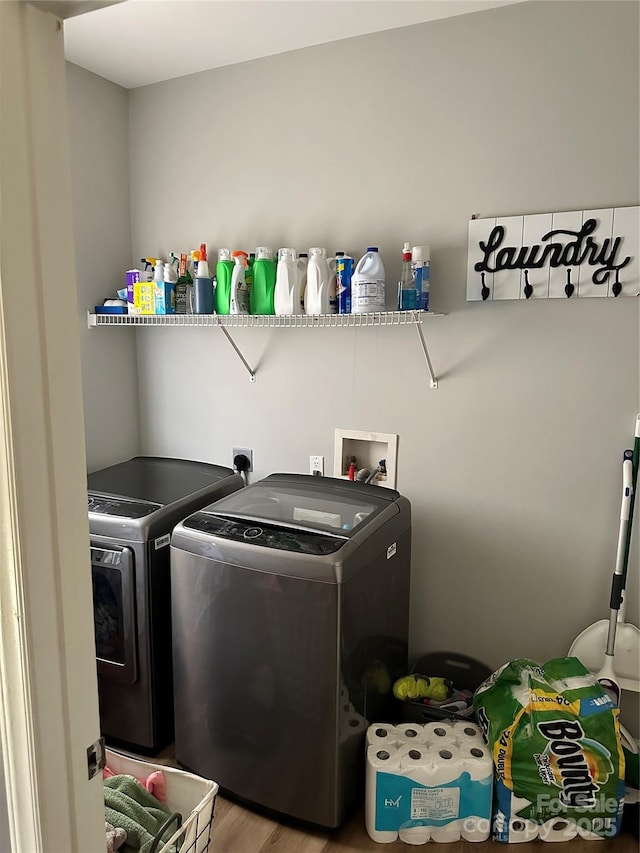 clothes washing area featuring laundry area, independent washer and dryer, and wood finished floors