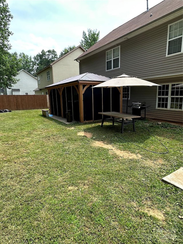 view of yard with fence and a sunroom