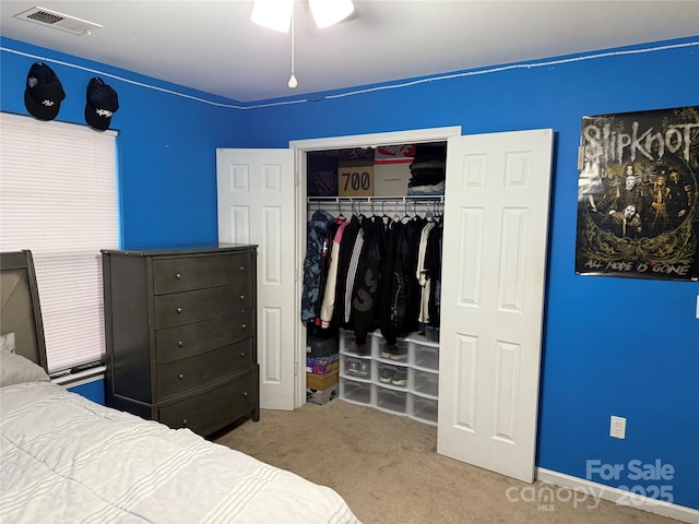 carpeted bedroom featuring a closet and visible vents