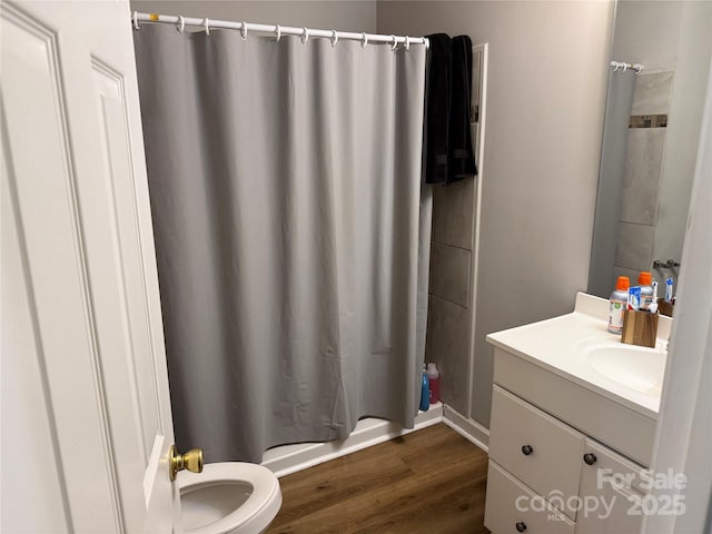 bathroom with toilet, wood finished floors, and vanity