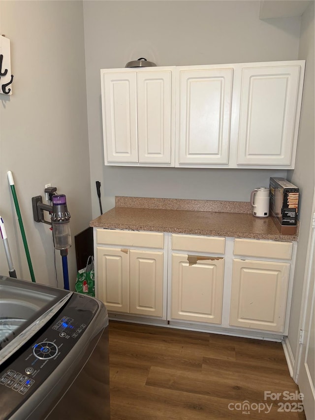 laundry room with cabinet space and dark wood-type flooring