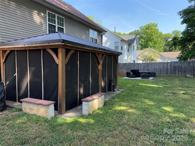 9624 Langston Mill Rd, Charlotte, NC 28216 - back of house featuring a sunroom, a fire pit, fence, and a yard