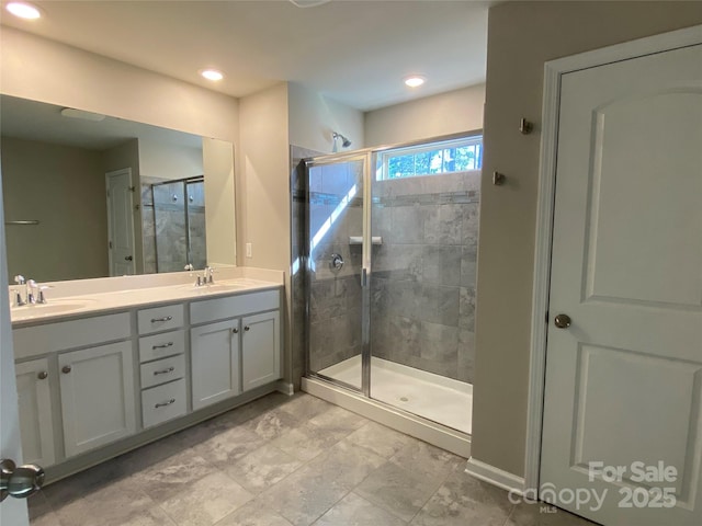 bathroom with a shower with door and vanity