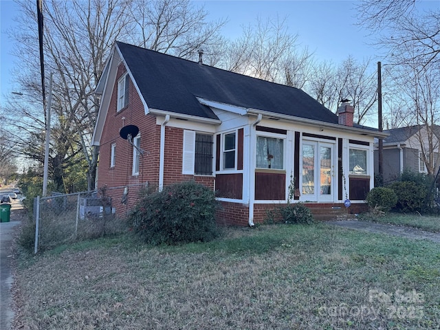 view of front of home featuring a front lawn and a sunroom