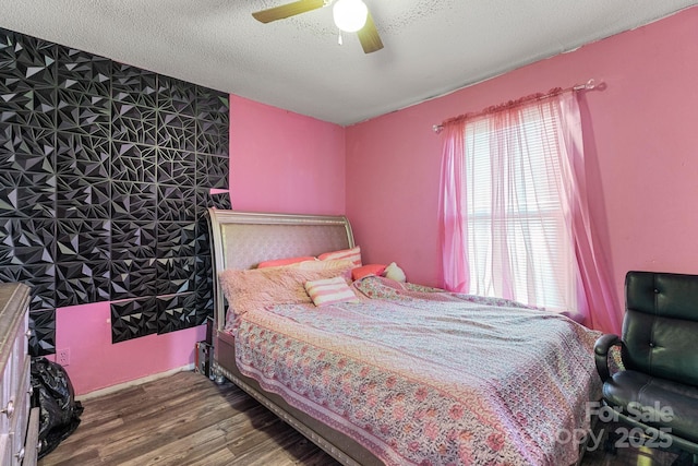 bedroom featuring dark hardwood / wood-style flooring, a textured ceiling, and ceiling fan