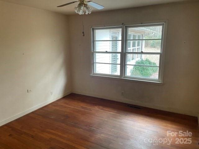 empty room featuring ceiling fan and dark hardwood / wood-style flooring