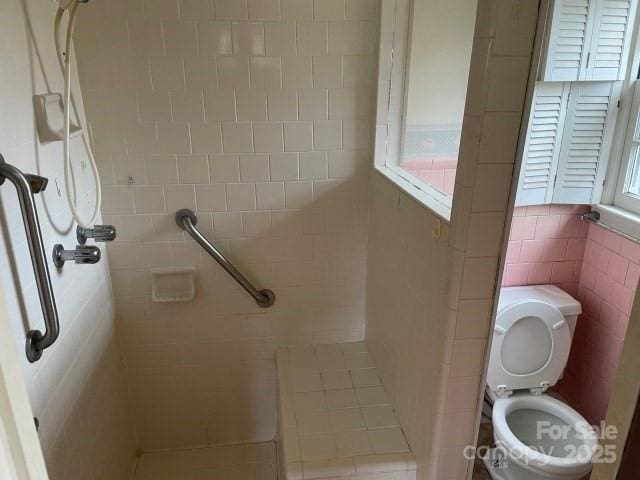 bathroom featuring toilet and tiled shower