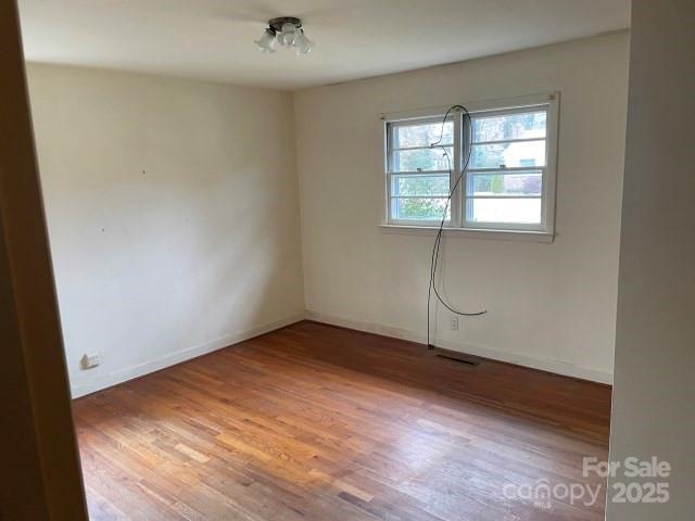 unfurnished room featuring hardwood / wood-style flooring