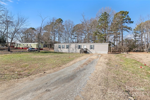 manufactured / mobile home with driveway and a front lawn