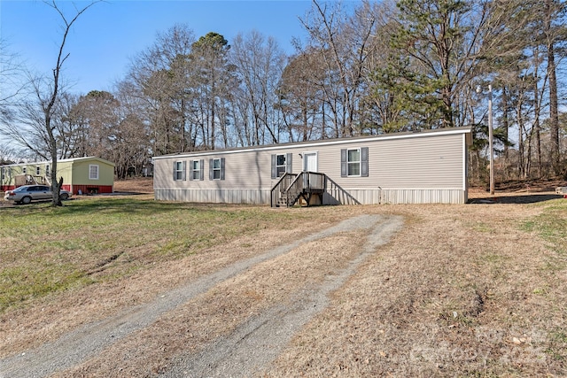 manufactured / mobile home featuring driveway and a front lawn