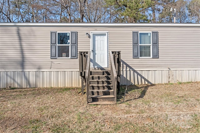 entrance to property with a lawn