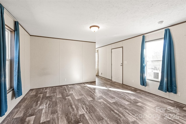 unfurnished bedroom with crown molding, a textured ceiling, and wood finished floors