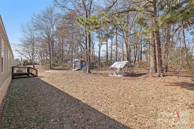 view of yard featuring an outdoor structure and a wooden deck