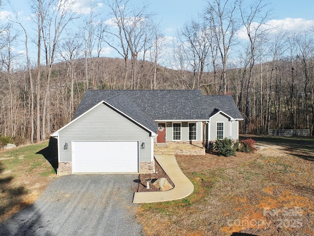 ranch-style home with a front yard, covered porch, and a garage