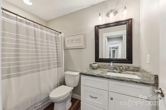 bathroom with toilet, vanity, a shower with curtain, and hardwood / wood-style floors