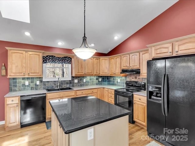 kitchen featuring black appliances, sink, vaulted ceiling, decorative light fixtures, and a kitchen island