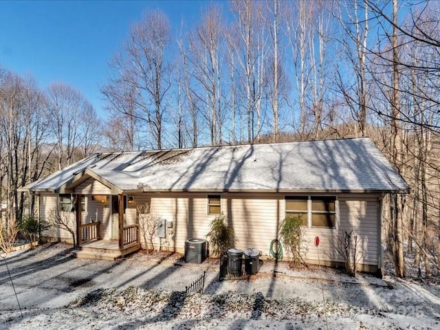 ranch-style home with a porch and central air condition unit