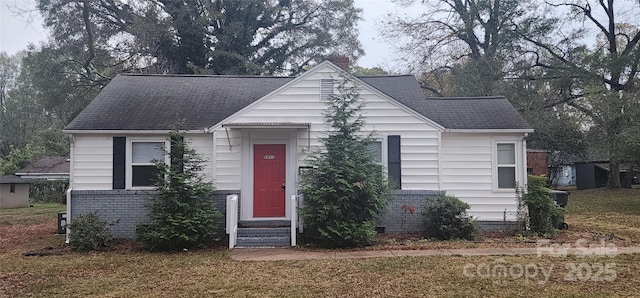 bungalow-style house featuring a front lawn