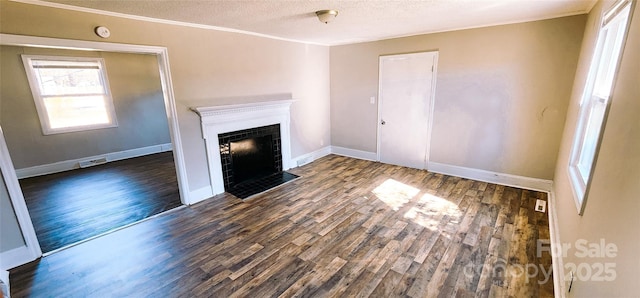 unfurnished living room with dark wood-type flooring, crown molding, and a textured ceiling