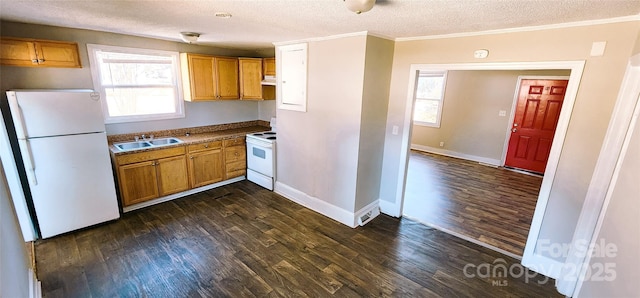 kitchen featuring white appliances, dark wood-type flooring, a textured ceiling, and sink