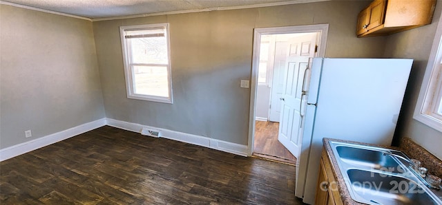 kitchen with dark hardwood / wood-style flooring, sink, white refrigerator, and a textured ceiling