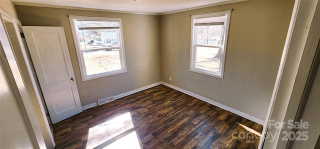 spare room with dark wood-type flooring and a textured ceiling