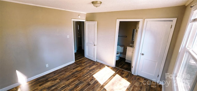 unfurnished bedroom with dark hardwood / wood-style flooring and ensuite bath