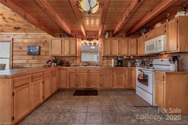 kitchen featuring sink, light brown cabinets, beamed ceiling, wood walls, and white appliances