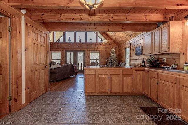 kitchen featuring beamed ceiling, wooden ceiling, and wooden walls