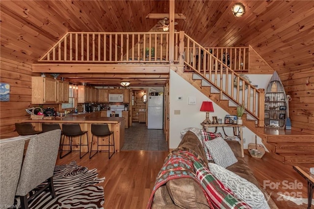 living room featuring wooden ceiling, dark wood-type flooring, and wooden walls