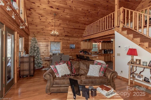 living room with hardwood / wood-style floors, high vaulted ceiling, a healthy amount of sunlight, and an inviting chandelier