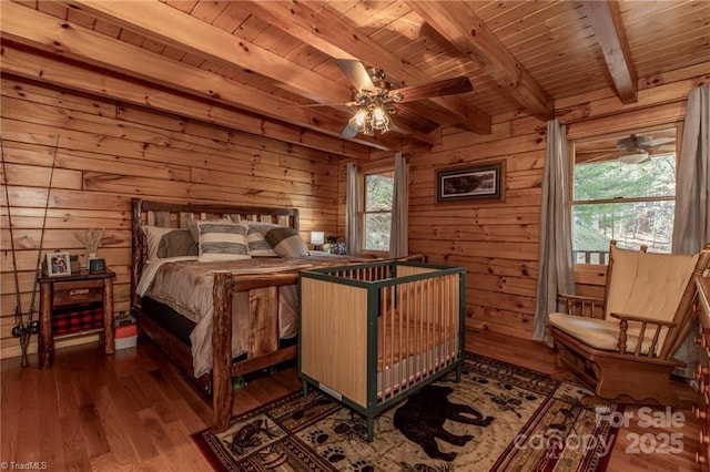 bedroom with wood walls, hardwood / wood-style floors, beamed ceiling, and wood ceiling