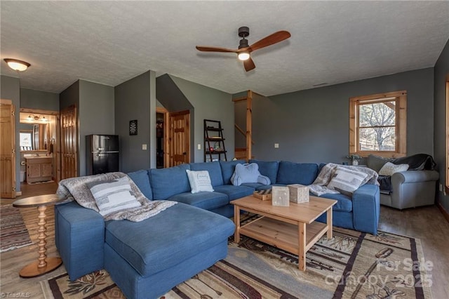 living room with ceiling fan, wood-type flooring, and a textured ceiling