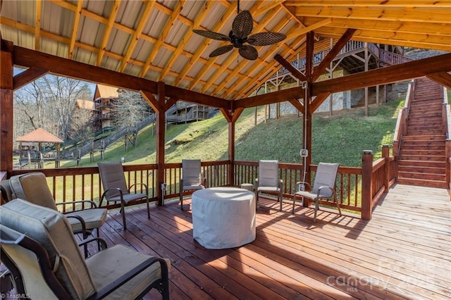 wooden deck featuring a gazebo, ceiling fan, and a yard