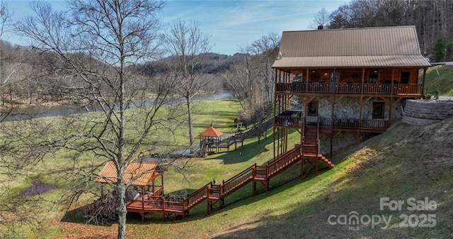 view of playground with a yard and a deck with water view