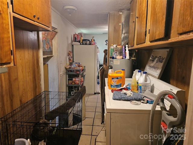 kitchen with a textured ceiling, wooden walls, light tile patterned floors, independent washer and dryer, and white fridge